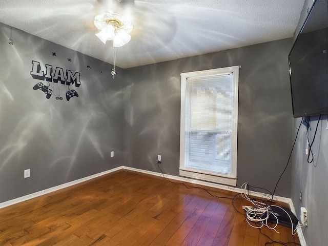 empty room featuring a textured ceiling and hardwood / wood-style flooring