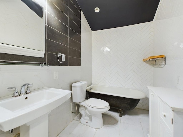 bathroom with a tub to relax in, toilet, tile walls, and sink