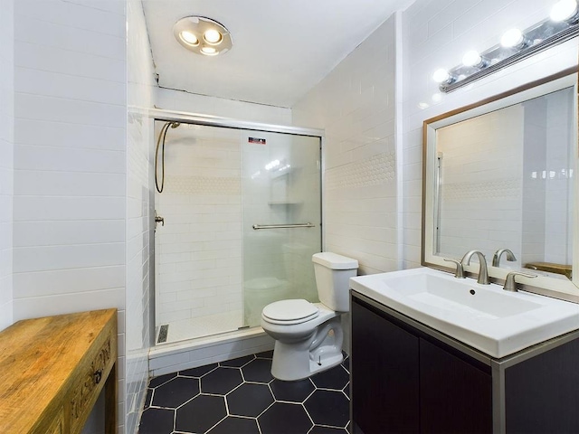 bathroom featuring vanity, toilet, and a shower with door