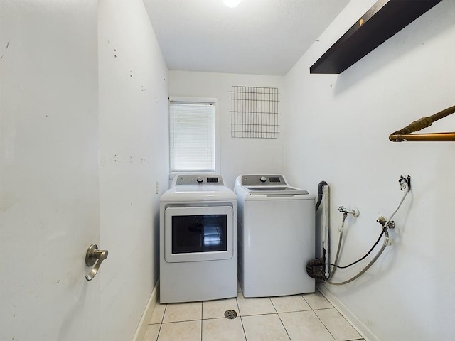 laundry area with light tile patterned floors and washing machine and clothes dryer