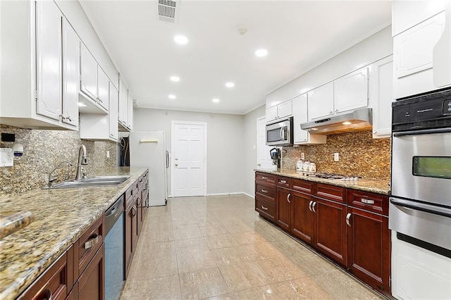 kitchen featuring decorative backsplash, sink, light stone counters, and appliances with stainless steel finishes