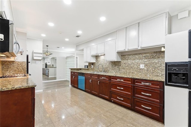 kitchen with light stone countertops, tasteful backsplash, stainless steel appliances, sink, and white cabinetry