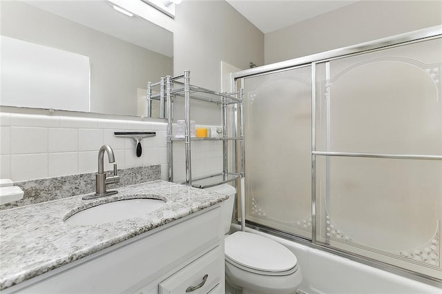 full bathroom featuring vanity, toilet, and bath / shower combo with glass door