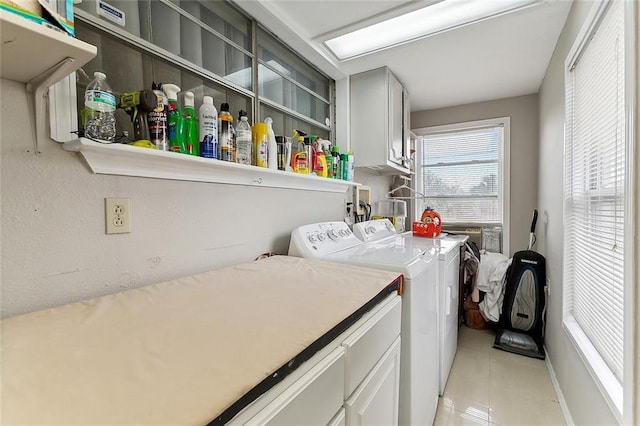 washroom with cabinets, light tile patterned floors, and washer and dryer