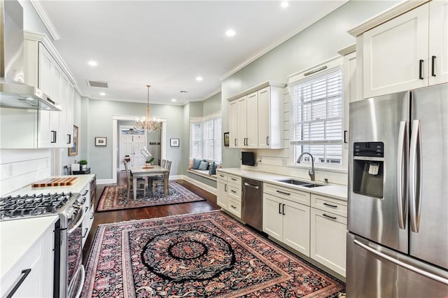 kitchen with stainless steel appliances, plenty of natural light, wall chimney exhaust hood, and sink