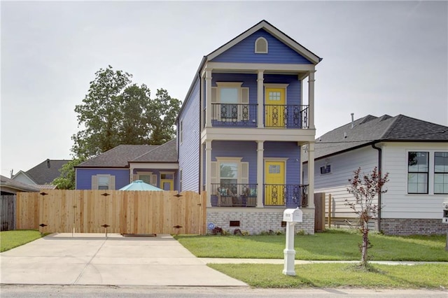 view of front of property featuring a balcony and a front lawn