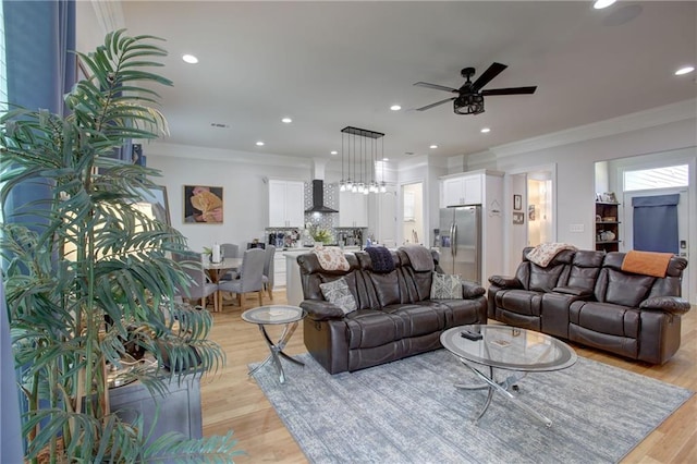 living room featuring crown molding, ceiling fan, and light hardwood / wood-style floors