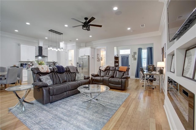 living room featuring light hardwood / wood-style flooring, ceiling fan, and ornamental molding