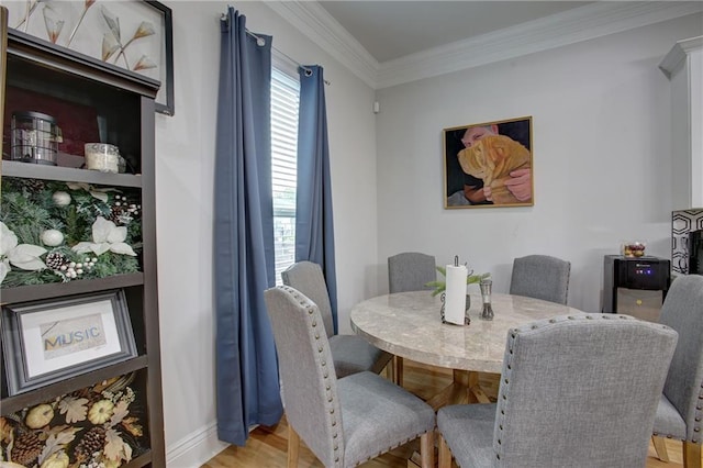 dining space featuring light hardwood / wood-style flooring and ornamental molding