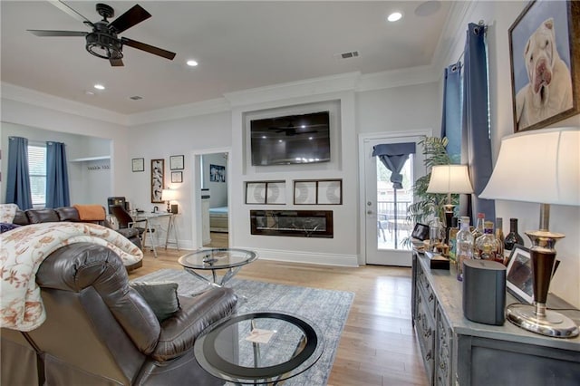 living room featuring light wood-type flooring, ceiling fan, and crown molding