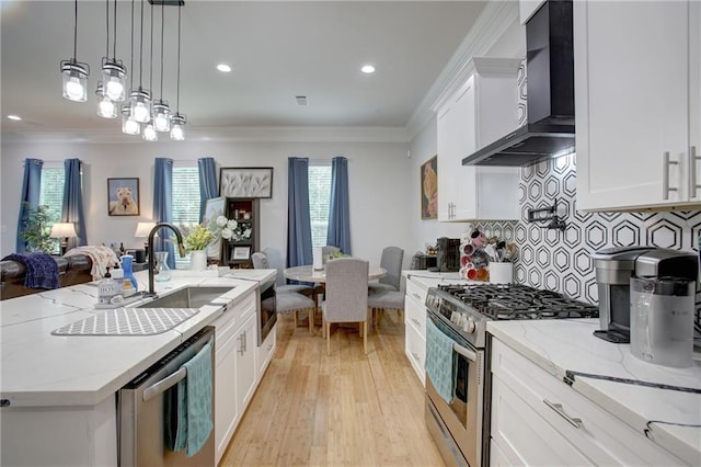 kitchen featuring white cabinetry, wall chimney exhaust hood, stainless steel appliances, light hardwood / wood-style flooring, and crown molding