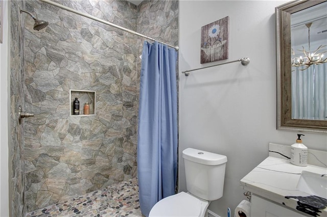 bathroom featuring vanity, toilet, walk in shower, and a chandelier