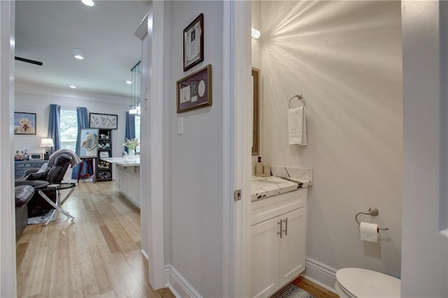 bathroom with hardwood / wood-style floors, vanity, and toilet