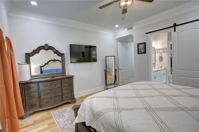 bedroom with ensuite bathroom, ceiling fan, a barn door, ornamental molding, and light hardwood / wood-style floors