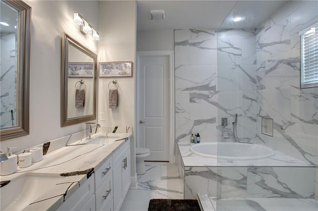 bathroom featuring tiled bath, vanity, and toilet