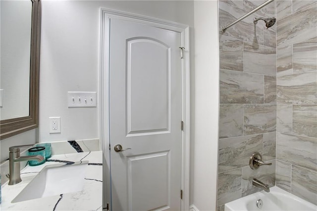 bathroom featuring vanity and tiled shower / bath