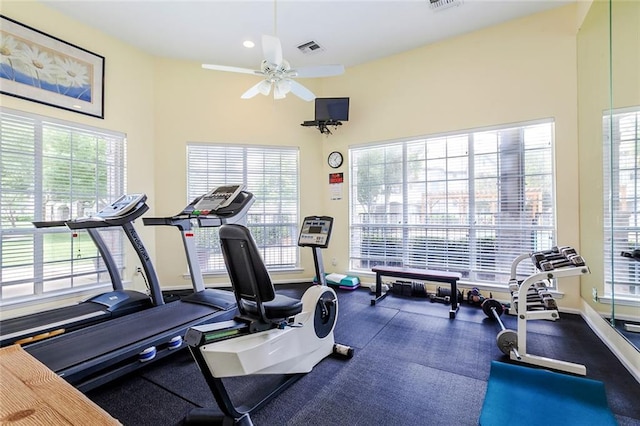 exercise room featuring a high ceiling, ceiling fan, and a healthy amount of sunlight