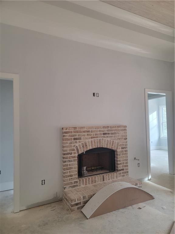 unfurnished living room featuring a fireplace and beamed ceiling