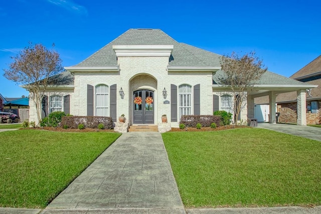 french provincial home featuring french doors, a front lawn, and a carport