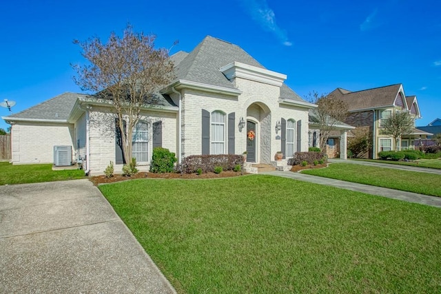 french country home featuring a front yard and central AC