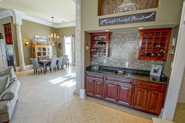 kitchen with tasteful backsplash, crown molding, light tile patterned floors, and pendant lighting