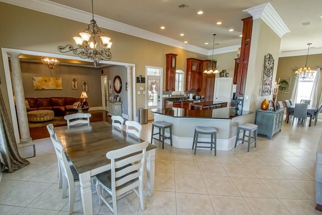 dining area with light tile patterned floors, decorative columns, and crown molding