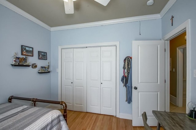 bedroom featuring ceiling fan, a closet, light hardwood / wood-style flooring, and ornamental molding