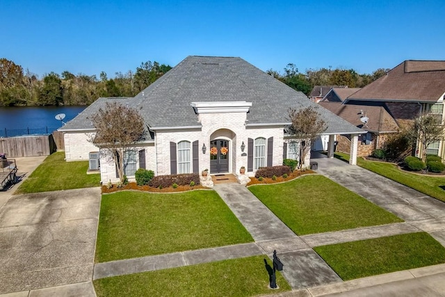 view of front of property featuring a water view, a front yard, and a carport