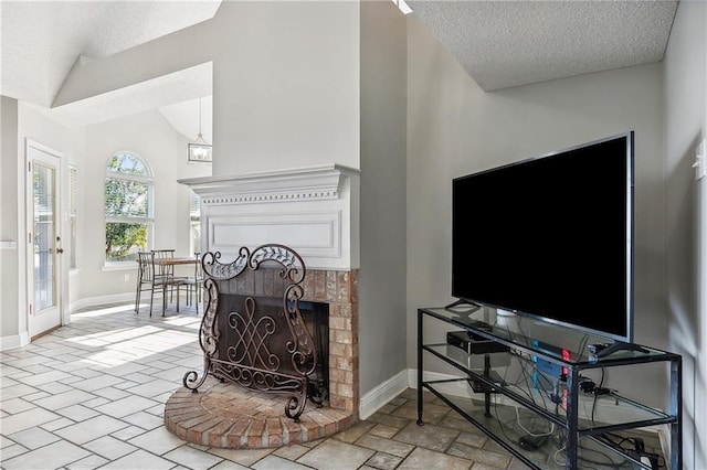 living room with a fireplace, a textured ceiling, and high vaulted ceiling