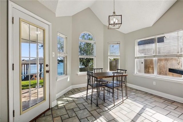 sunroom with an inviting chandelier, a wealth of natural light, and lofted ceiling