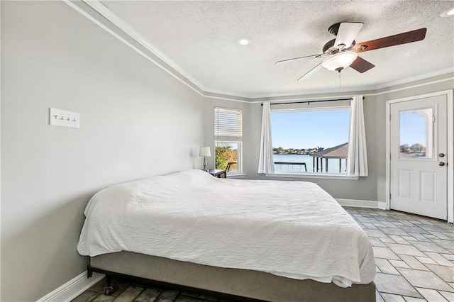 bedroom featuring ceiling fan, crown molding, and a textured ceiling