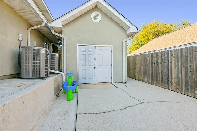 entrance to property featuring central AC unit and a patio area