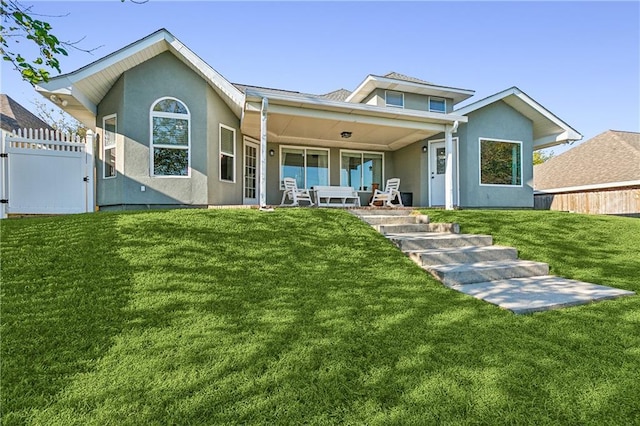 rear view of house featuring covered porch and a yard