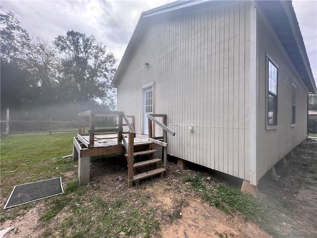 view of property exterior featuring a wooden deck and a yard