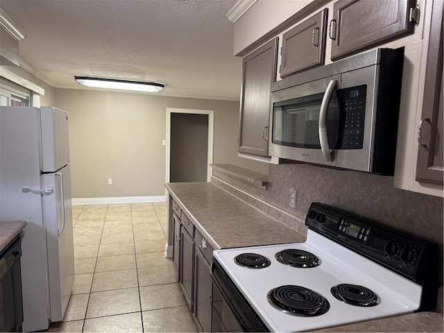 kitchen with decorative backsplash, light tile patterned flooring, dark brown cabinetry, and white appliances