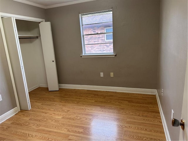 unfurnished bedroom featuring crown molding, a closet, and light hardwood / wood-style floors