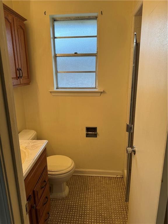 bathroom with tile patterned flooring, vanity, and toilet