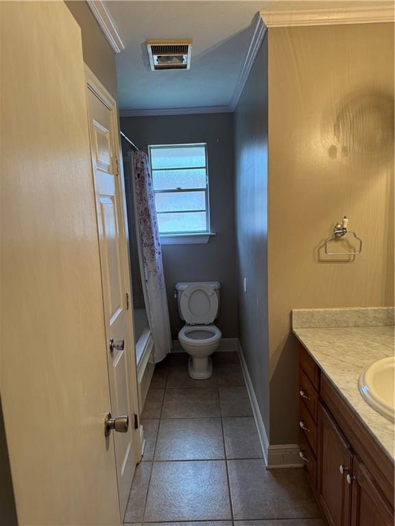 full bathroom with tile patterned floors, toilet, shower / tub combo with curtain, vanity, and ornamental molding