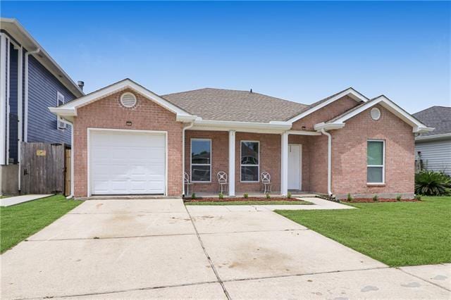 ranch-style house featuring a garage and a front lawn