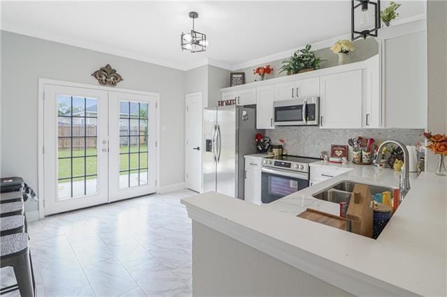 kitchen with white cabinets, crown molding, sink, hanging light fixtures, and appliances with stainless steel finishes