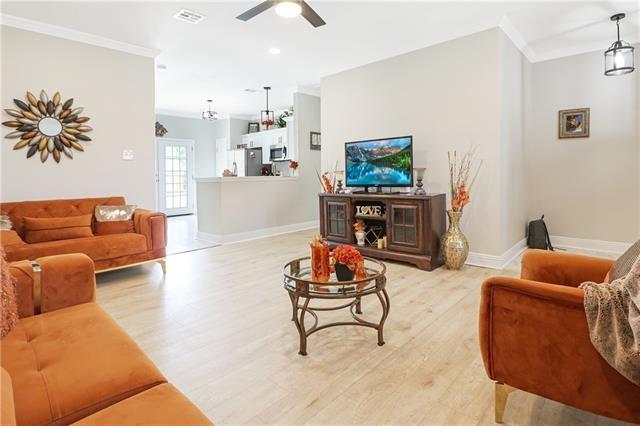 living room featuring light hardwood / wood-style flooring, ceiling fan, and crown molding