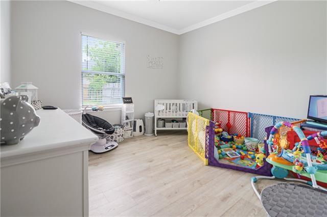 bedroom with hardwood / wood-style flooring and ornamental molding