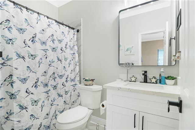 bathroom featuring a shower with curtain, vanity, and toilet