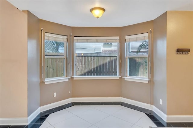 spare room featuring a healthy amount of sunlight and tile patterned floors