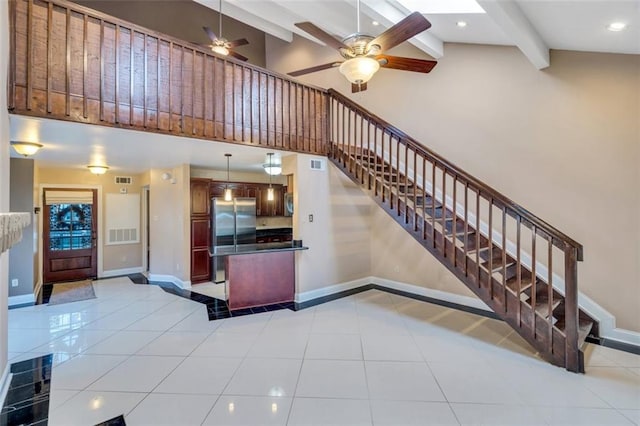 kitchen featuring high vaulted ceiling, hanging light fixtures, light tile patterned floors, stainless steel fridge, and beamed ceiling