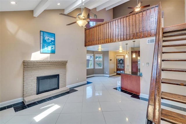 unfurnished living room with light tile patterned floors, ceiling fan, high vaulted ceiling, a fireplace, and beamed ceiling