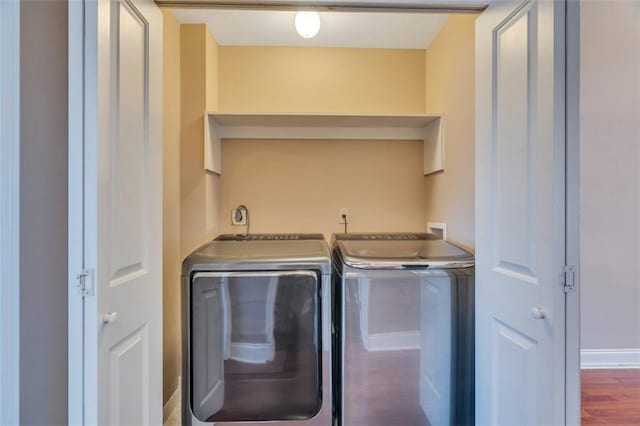 clothes washing area with dark hardwood / wood-style floors and separate washer and dryer