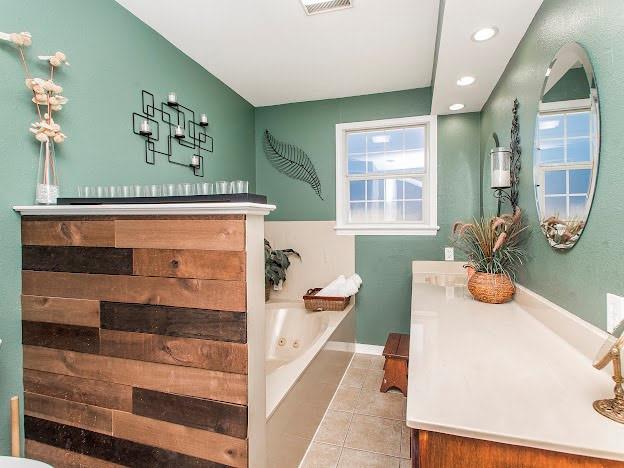 bathroom with vanity, tile patterned floors, and a tub to relax in