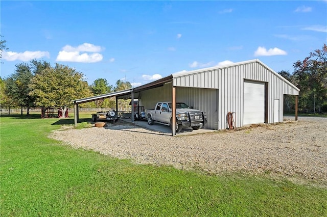 view of outbuilding featuring a lawn, a carport, and a garage