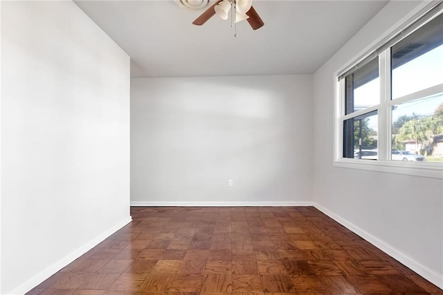 empty room featuring ceiling fan and dark parquet flooring